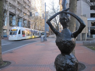 A figure in Conkle's 2009 "Burls will be Burls" appears to look into the distance as a light rail train approaches (photo by Anita Malhotra)