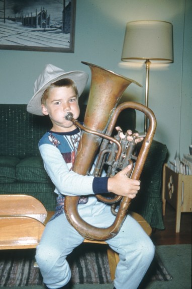Frisell as a youngster in Denver, Colorado playing a euphonium that his grandfather, Wilhelm, used to play in a community orchestra. Behind him is a painting by his father, Olof (photo courtesy of Bill Frisell)