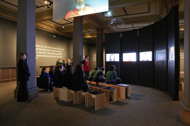 An audience viewing the video installation “Question Bridge” (photo courtesy of Hank Willis Thomas and Jack Shainman Gallery)