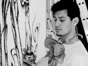 Nasca Uno in 2012 painting a mural on a demolished house (photo courtesy of Nasca Uno)